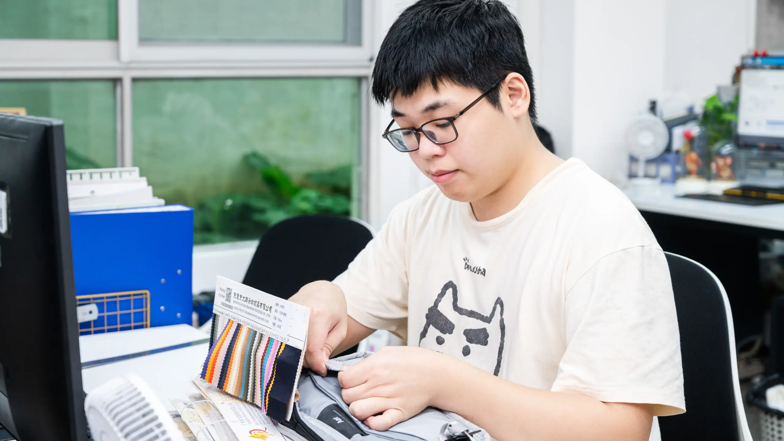 Reviewing handbag fabric swatches and hardware during sample development