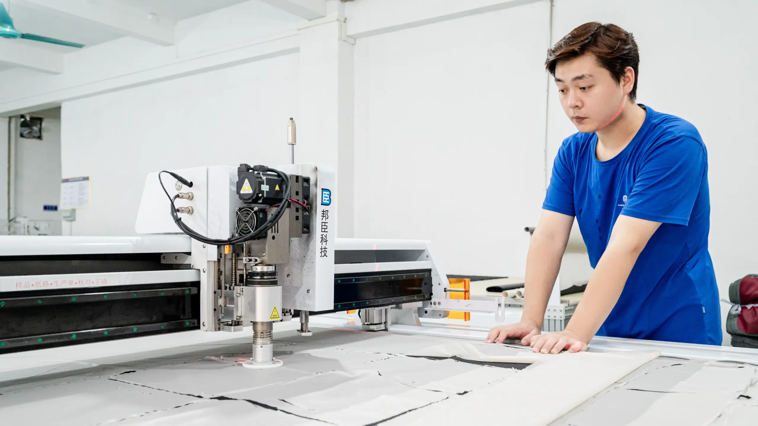 Machine operator at a CNC cutting station in a bag factory production flow