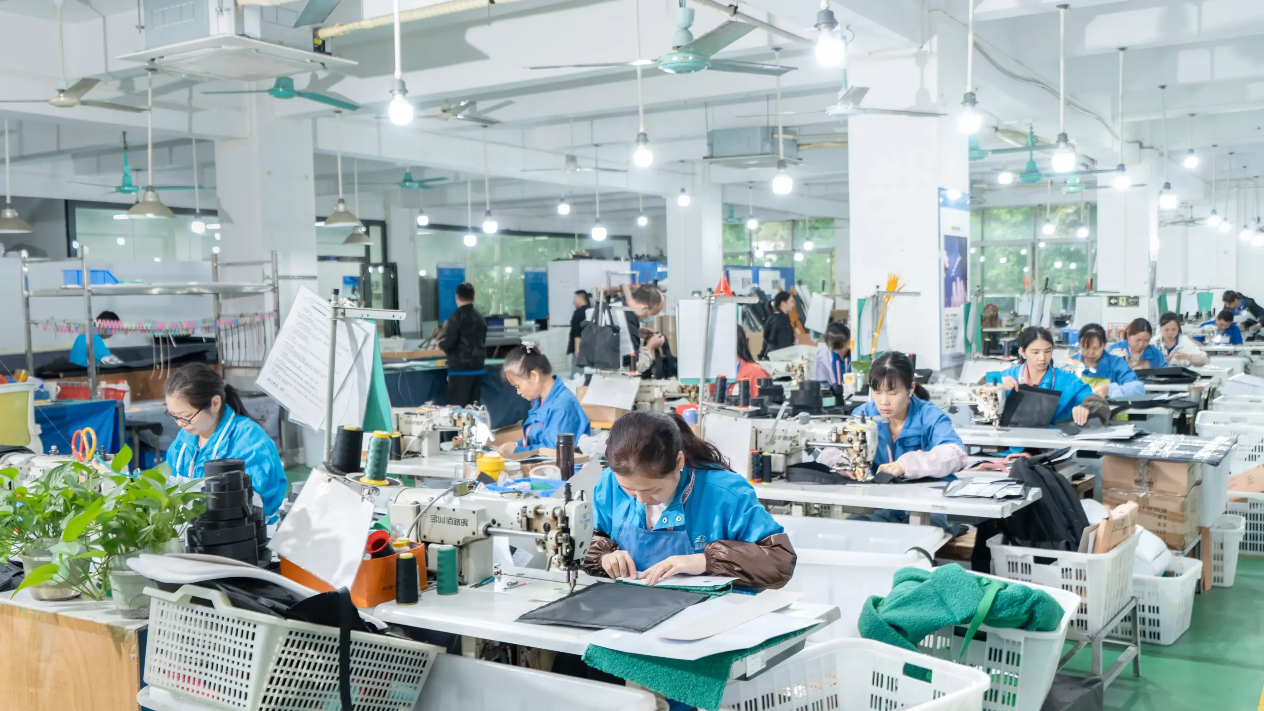 Skilled workers sewing school bags on a production line